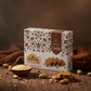 Chocolate peanut chikki 500g box with chikki pieces on wooden table