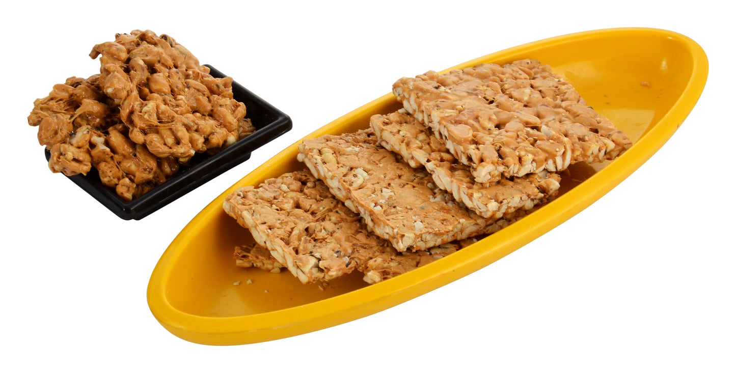 Chocolate peanut chikki 500g box with chikki pieces on wooden table