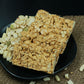 Chocolate peanut chikki 500g box with chikki pieces on wooden table