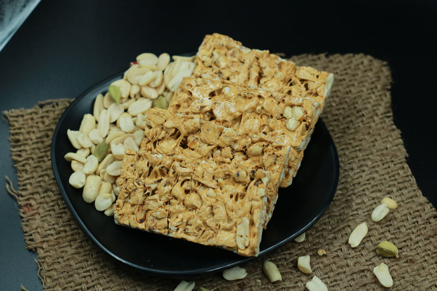 Chocolate peanut chikki 500g box with chikki pieces on wooden table