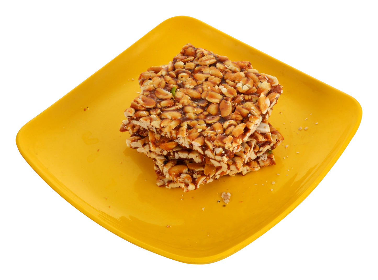 Crispy peanut jaggery chikki stacked on blue cloth