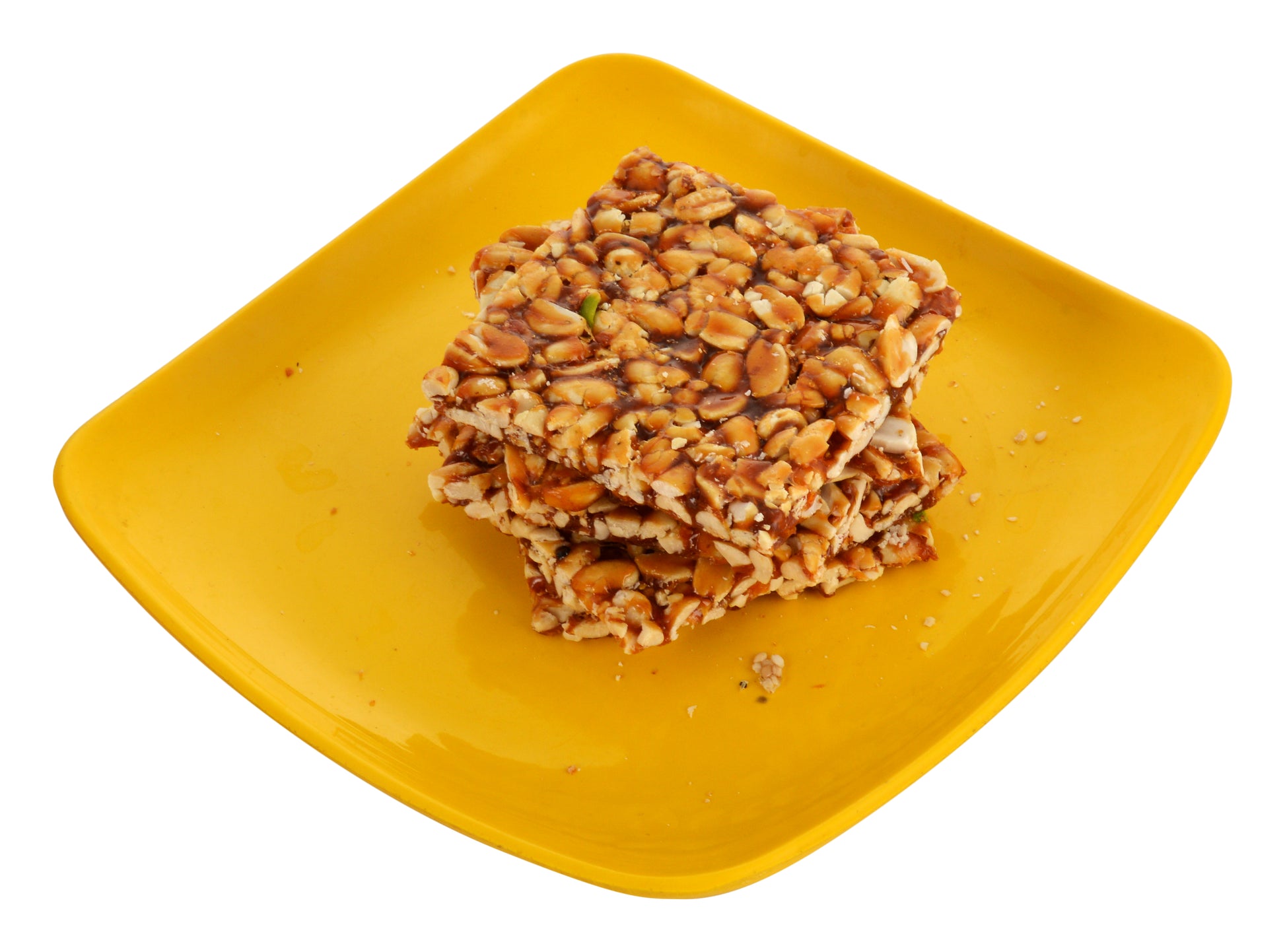 Crispy peanut jaggery chikki stacked on blue cloth