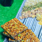Crispy peanut jaggery chikki stacked on blue cloth