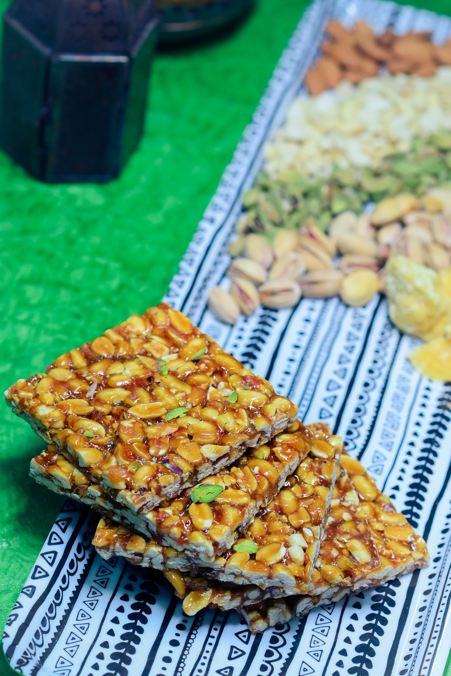 Crispy peanut jaggery chikki stacked on blue cloth