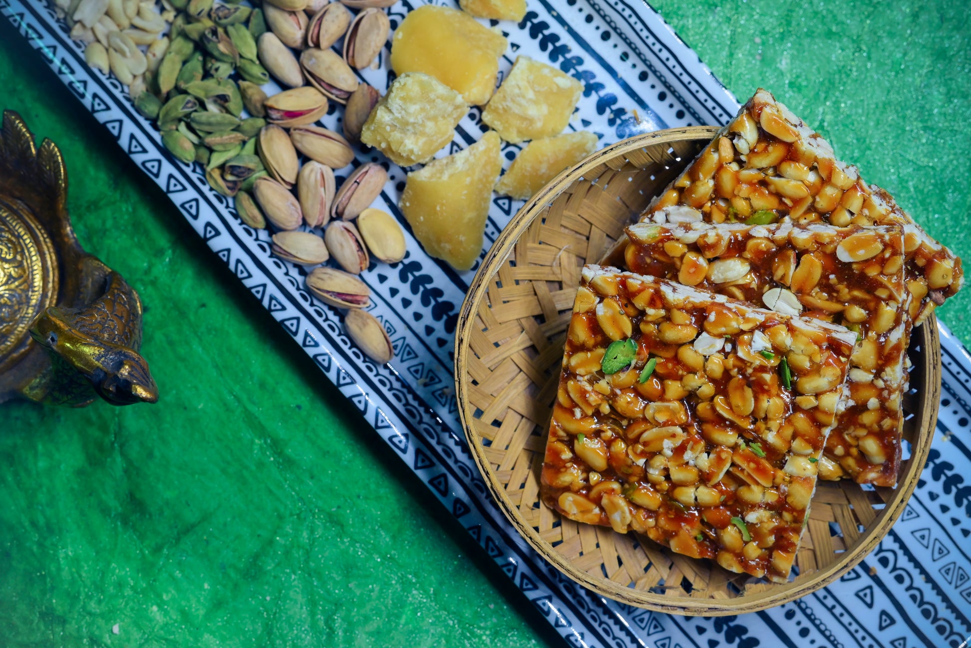 Crispy peanut jaggery chikki stacked on blue cloth
