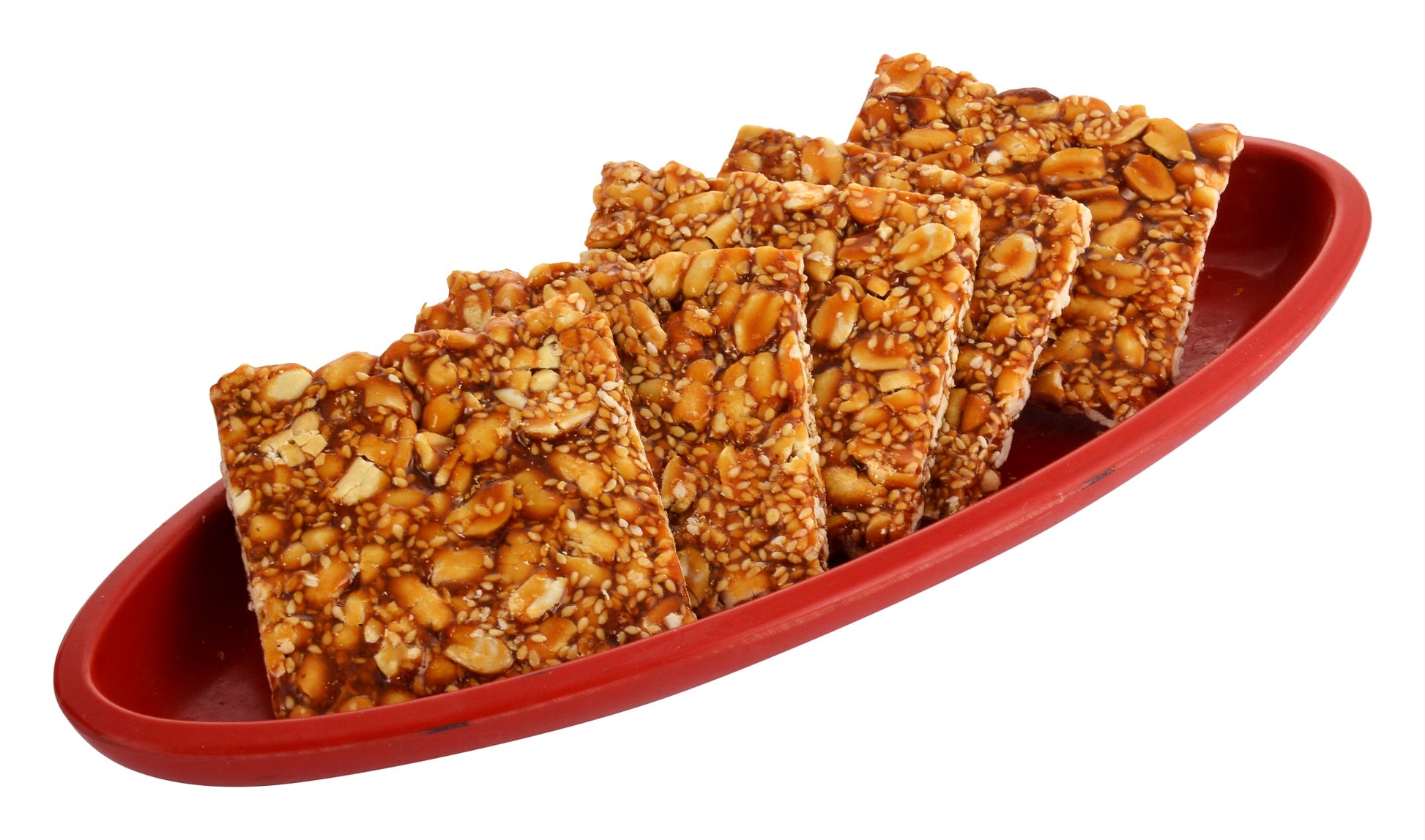 Crispy peanut and sesame chikki squares in blue box