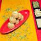 Traditional Mewabati mithai arranged on decorative festive background